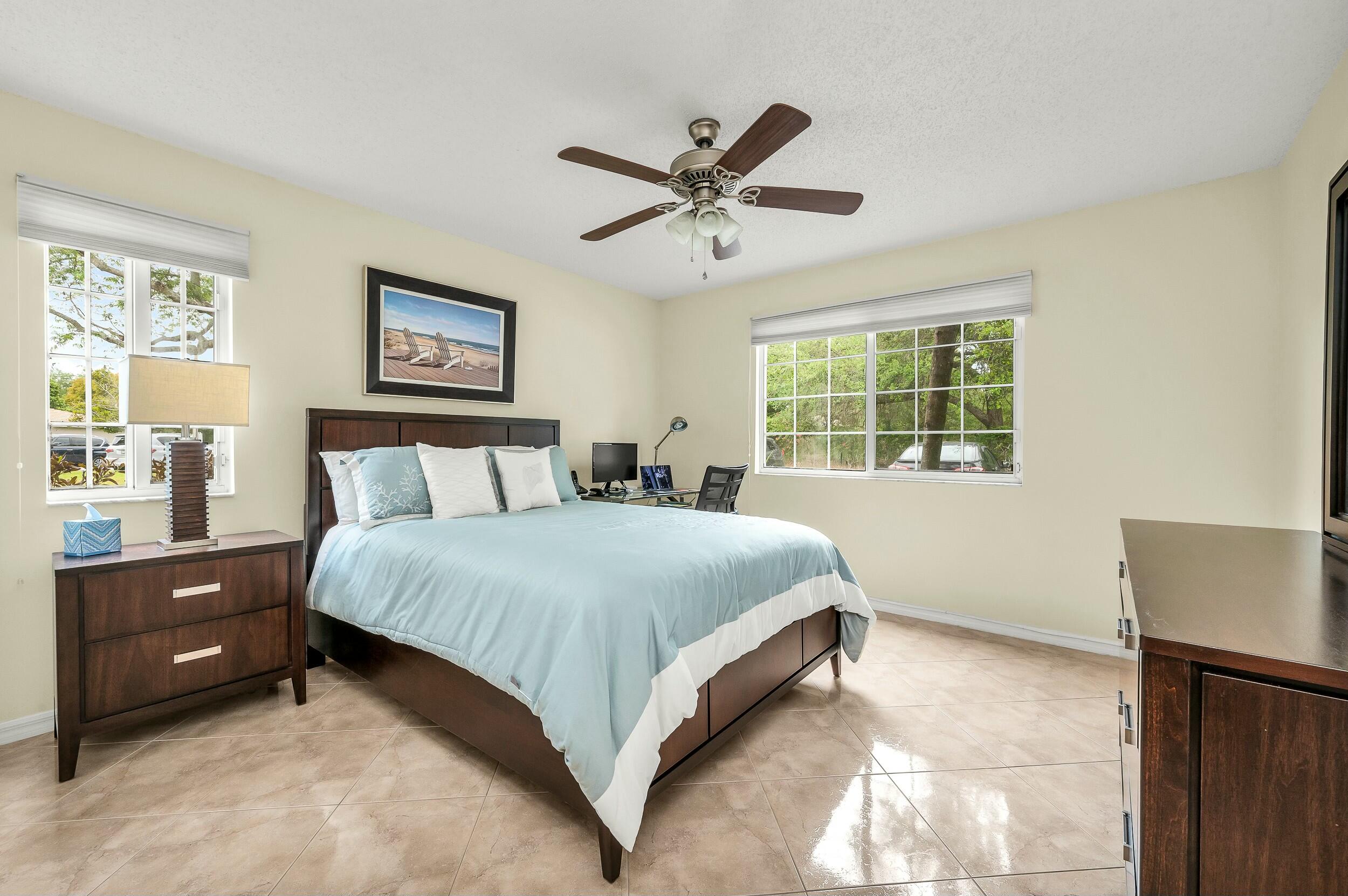 5031 Wiles Road, Unit 107 Coconut Creek, FL 33073 - Photo 5 of 22 a bedroom with a bed and a window