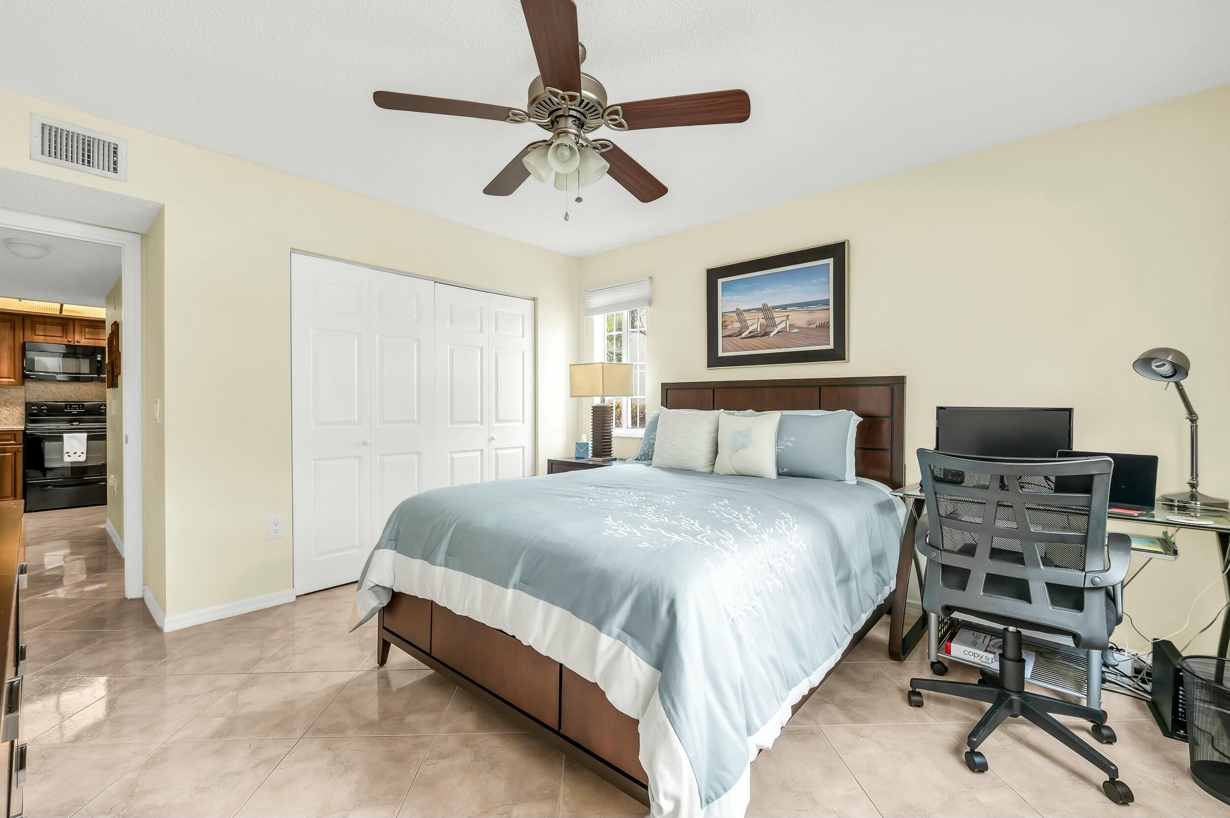 5031 Wiles Road, Unit 107 Coconut Creek, FL 33073 - Photo 6 of 22 a bedroom with a bed and a chair