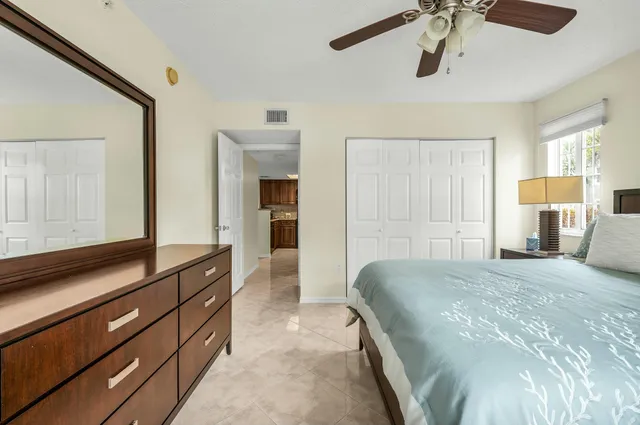 a spacious bedroom with a bed and a dresser