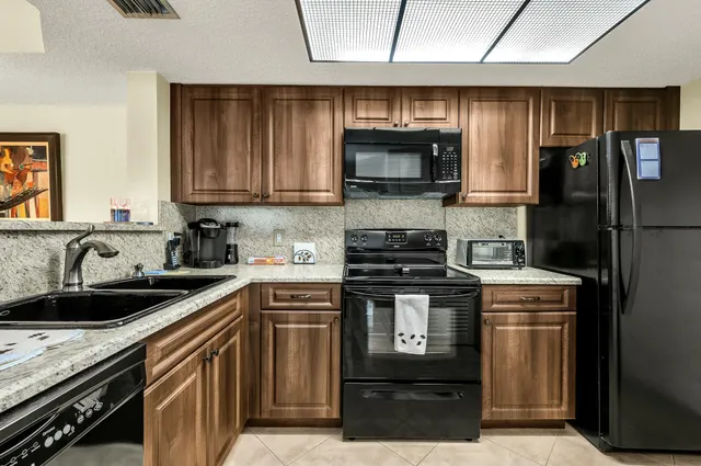 a kitchen with stainless steel appliances granite countertop a stove a sink and a refrigerator