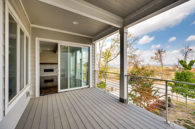 a large kitchen with stainless steel appliances kitchen island granite countertop a stove a sink a refrigerator and white cabinets with wooden floor