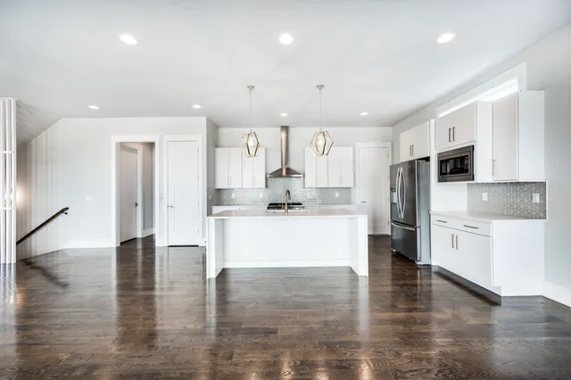 a kitchen with stainless steel appliances granite countertop a sink a stove and cabinets
