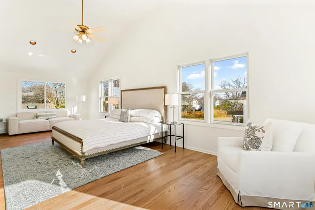 a bedroom with a large bed couch and a window