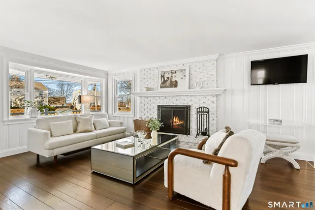 a living room with furniture a flat screen tv and a fireplace