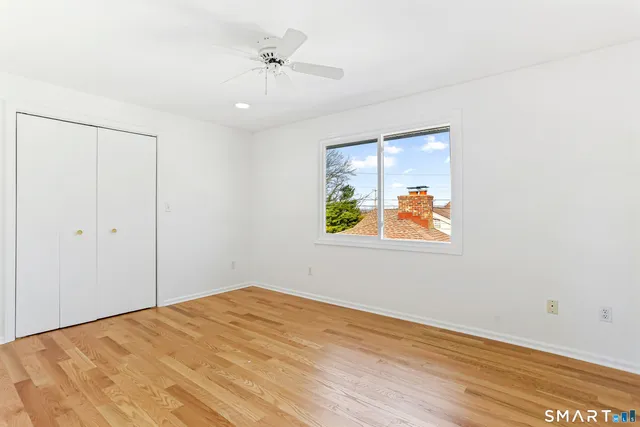 a view of empty room with window and wooden floor