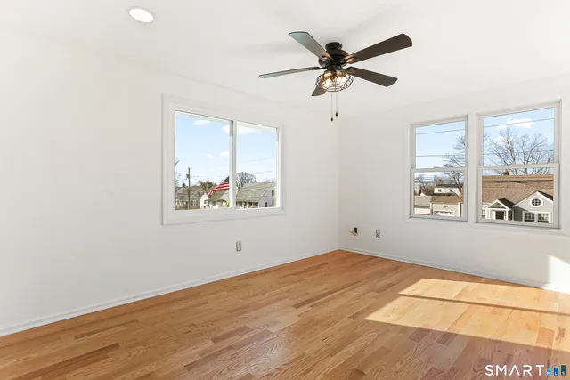 a view of a big room with wooden floor and a ceiling fan