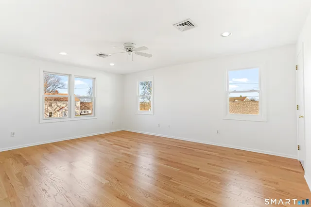 an empty room with wooden floor and window