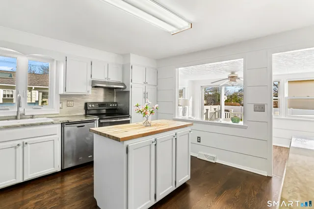 a kitchen with granite countertop white cabinets and white appliances