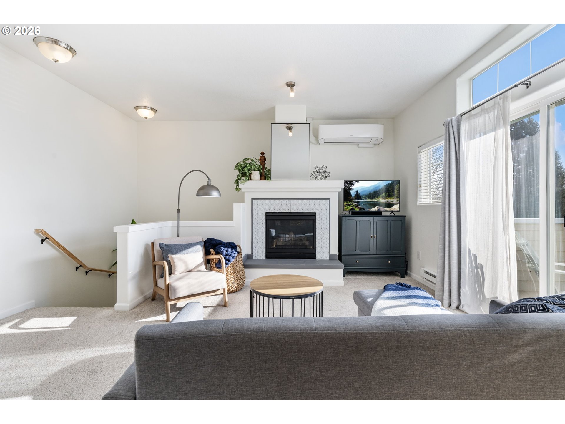 14705 Southwest Sandhill Loop, Unit 202 Beaverton, OR 97007 - Photo 20 of 24 a living room with furniture a fireplace and a chandelier