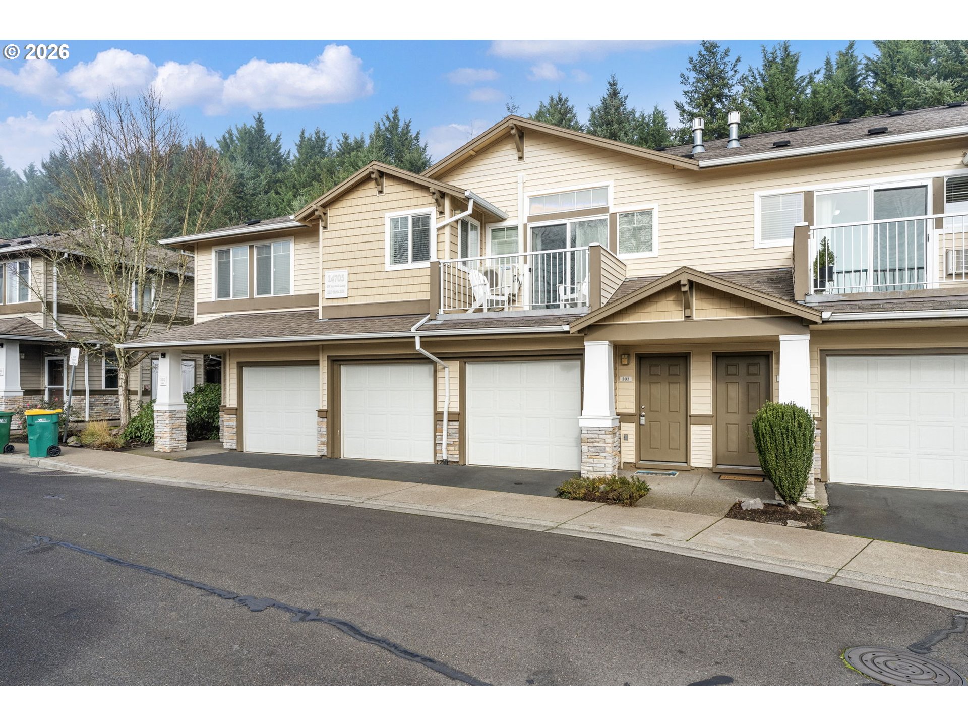 14705 Southwest Sandhill Loop, Unit 202 Beaverton, OR 97007 - Photo 23 of 24 a view of a white house with large windows and a small yard