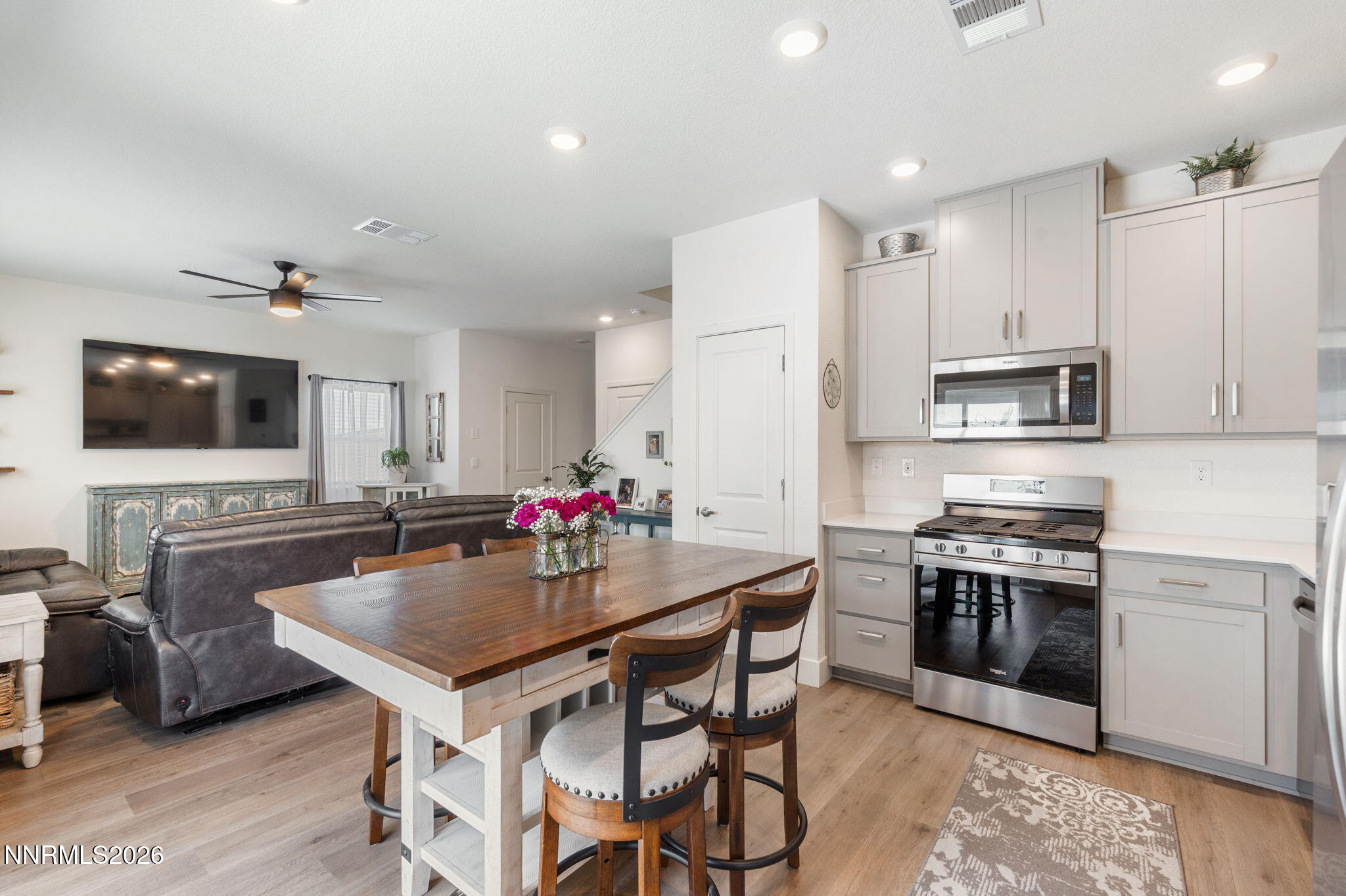7999 Majorite Way Sparks, NV 89436 - Photo 11 of 26 a kitchen with stainless steel appliances granite countertop a stove top oven a sink dishwasher a dining table and chairs with wooden floor