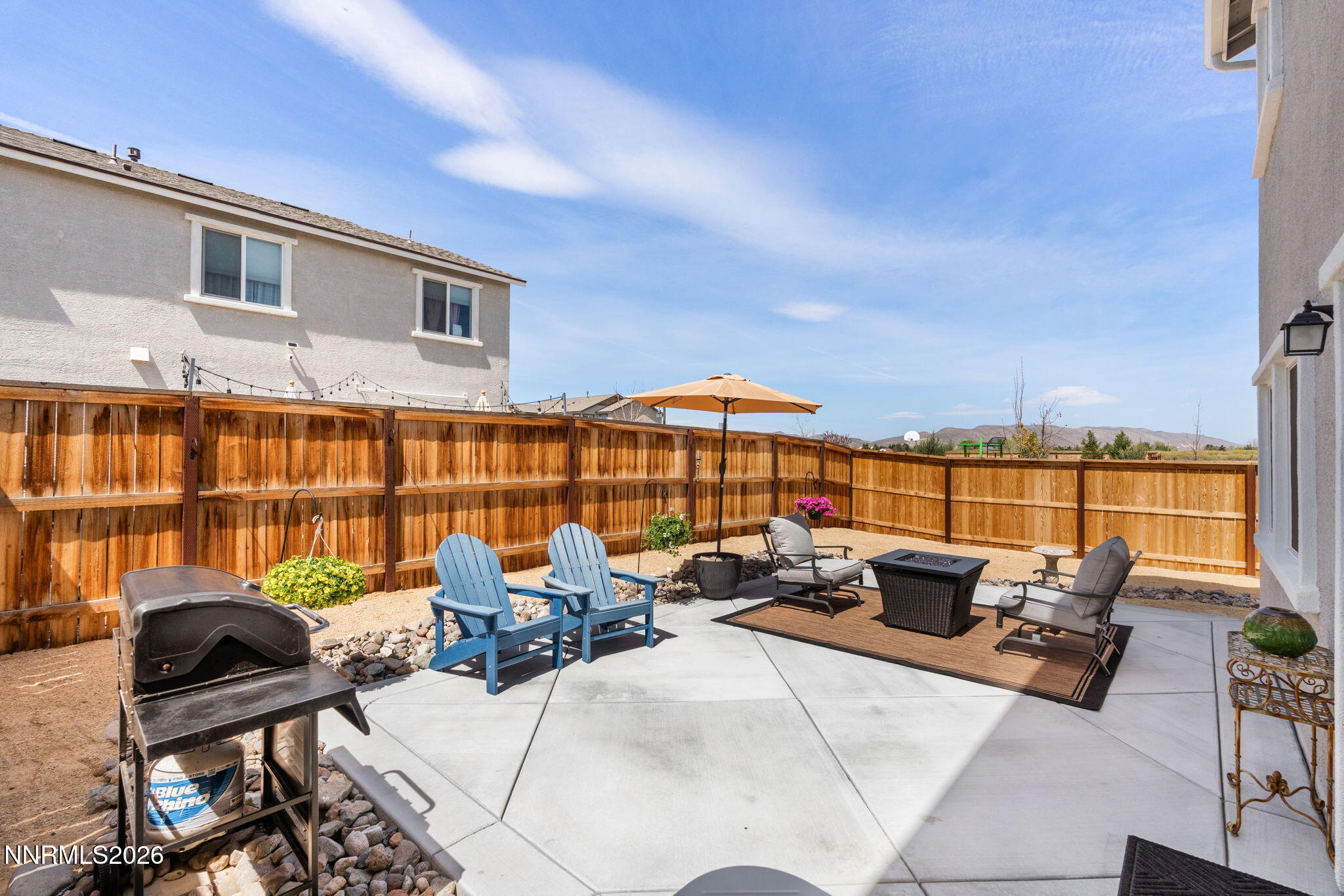 7999 Majorite Way Sparks, NV 89436 - Photo 23 of 26 a view of a patio with couches chairs under an umbrella next to a yard