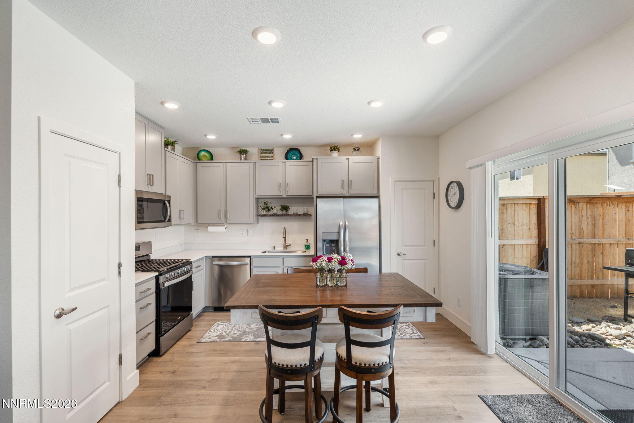 7999 Majorite Way Sparks, NV 89436 - Photo 9 of 26 a kitchen with stainless steel appliances kitchen island granite countertop a dining table chairs and refrigerator