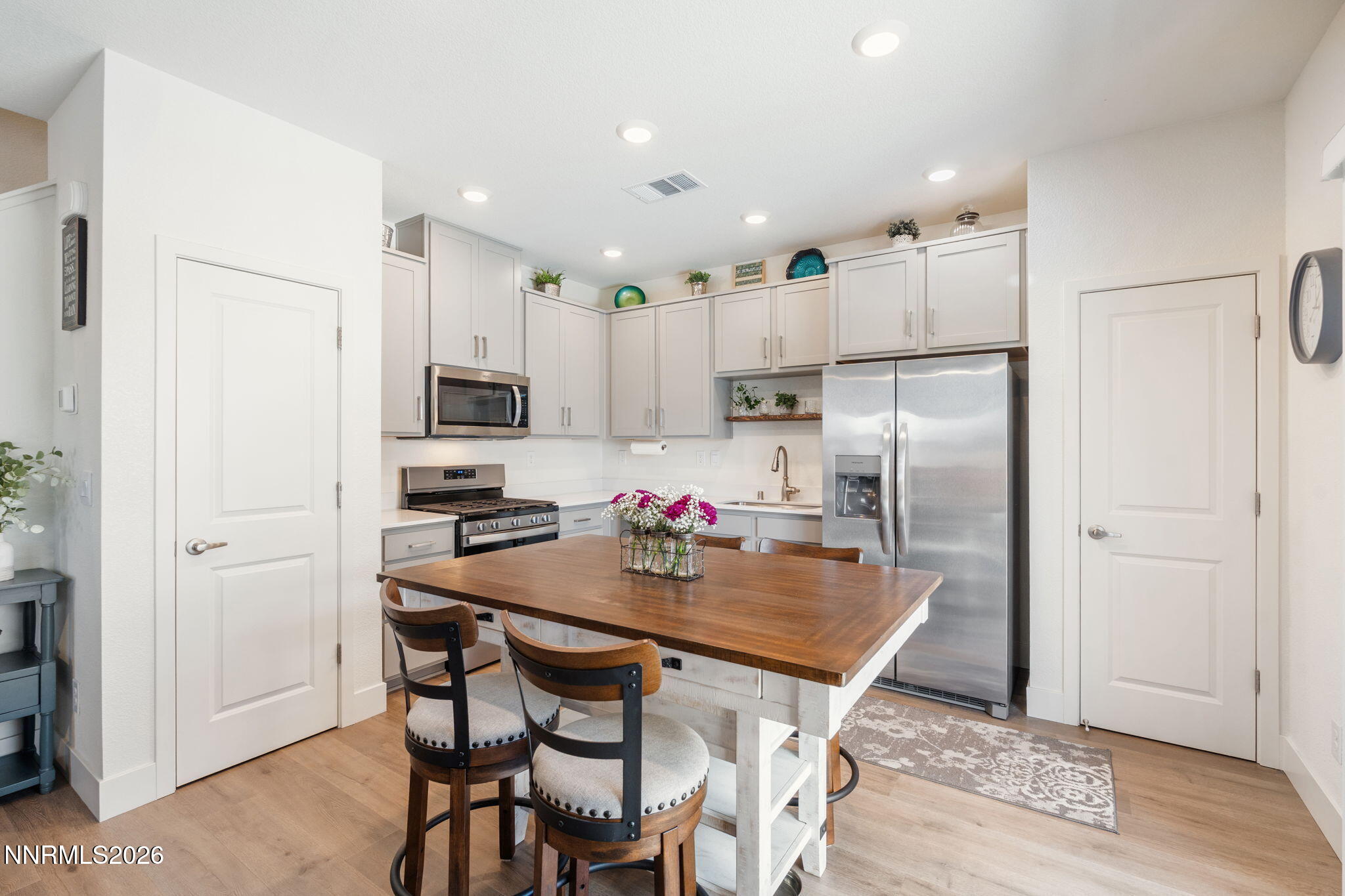 7999 Majorite Way Sparks, NV 89436 - Photo 10 of 26 a kitchen with a dining table chairs refrigerator and microwave