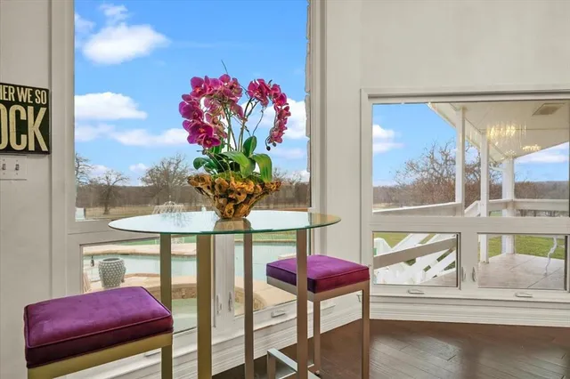 a vase of flowers sitting on a table with a glass door