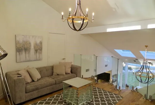a living room with furniture a dining table and a chandelier