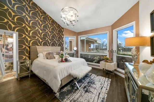 a bedroom with a large bed and a chandelier