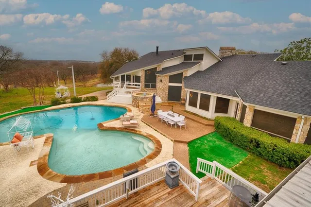 an aerial view of a house with swimming pool and outdoor seating