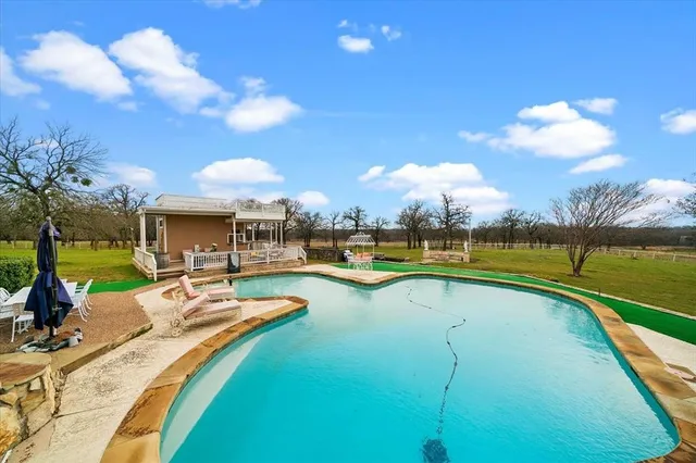 a view of a swimming pool and lounge chairs