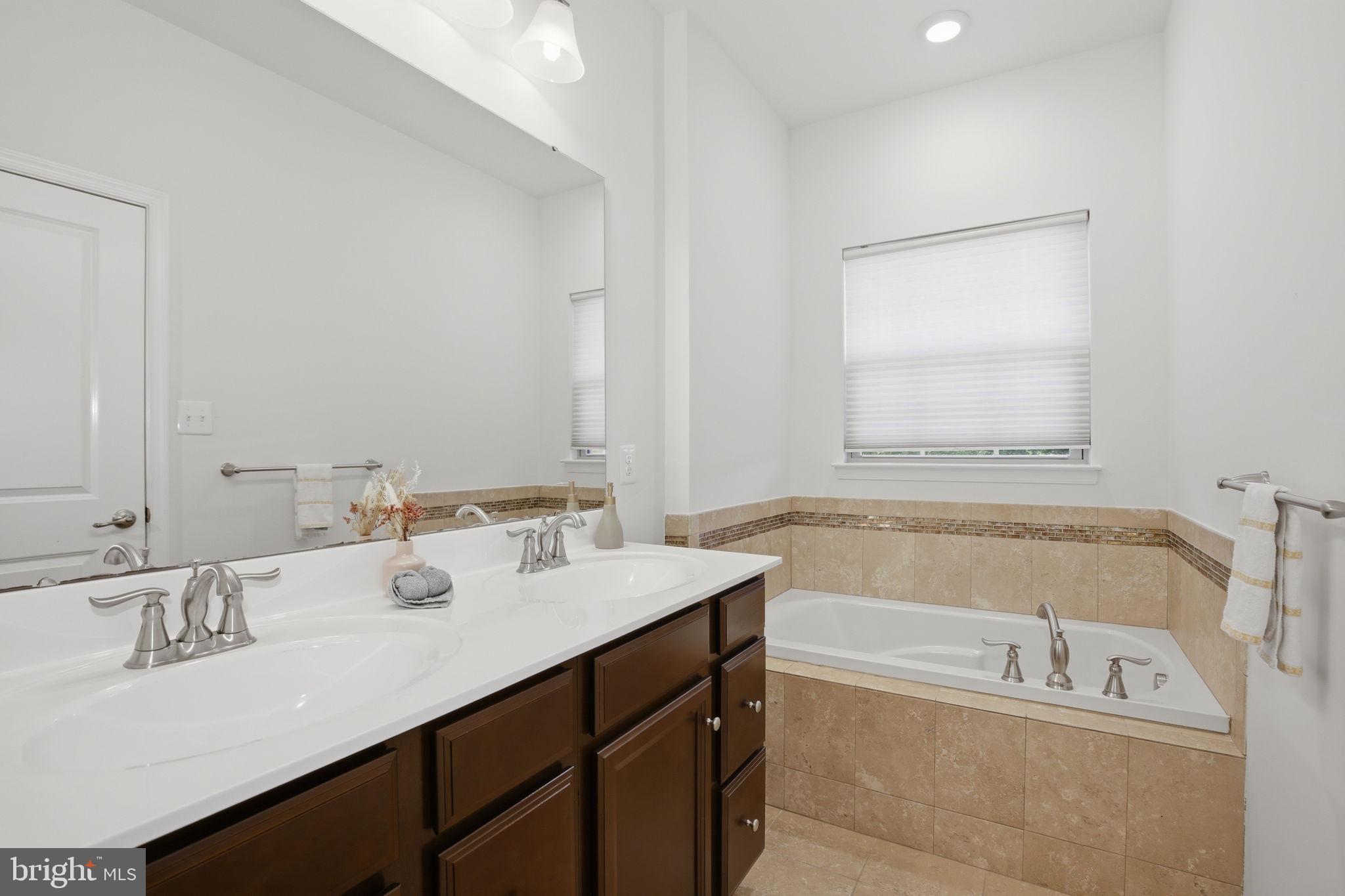 2784 Fredericksburg Road Hanover, MD 21076 - Photo 37 of 60 a bathroom with a tub sink and mirror