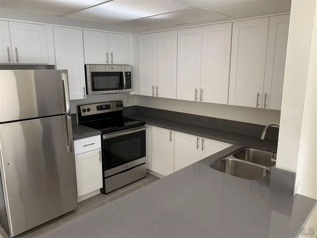 6064 Rancho Mission Road, Unit 448 San Diego, CA 92108 - Photo 2 of 15 a kitchen with stainless steel appliances a refrigerator stove and microwave