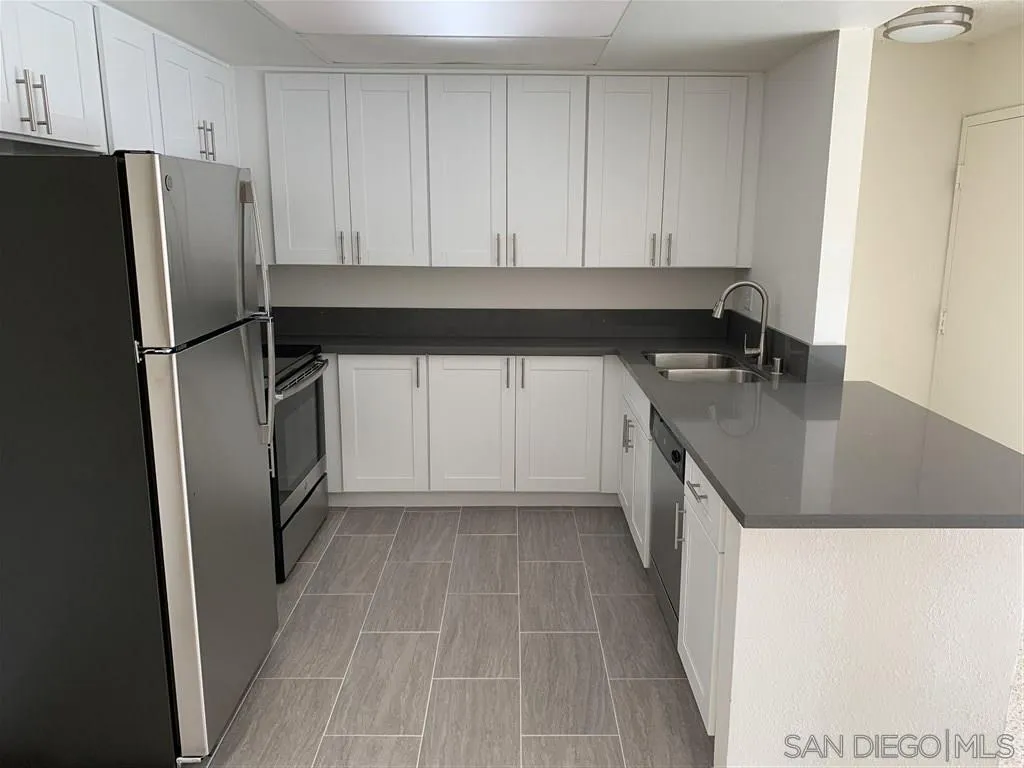 6064 Rancho Mission Road, Unit 448 San Diego, CA 92108 - Photo 3 of 15 a kitchen with a refrigerator sink and cabinets
