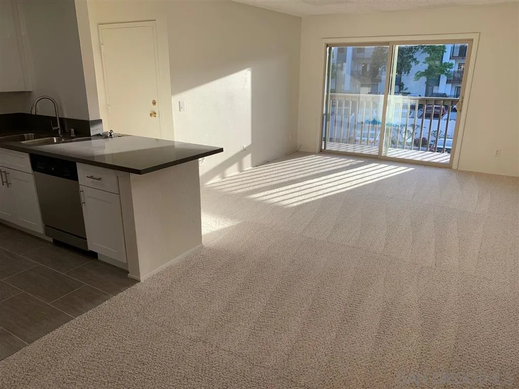 6064 Rancho Mission Road, Unit 448 San Diego, CA 92108 - Photo 10 of 15 a kitchen with stainless steel appliances granite countertop a sink a stove and a refrigerator