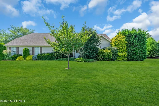 a front view of a house with a yard and trees