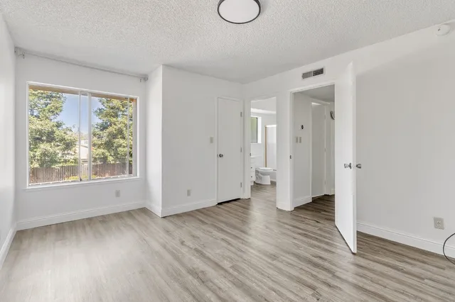 an empty room with wooden floor and windows