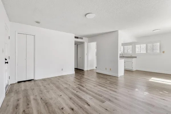 a view of empty room with wooden floor and windows