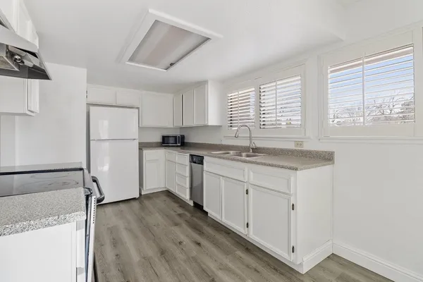 a kitchen with white cabinets and white appliances