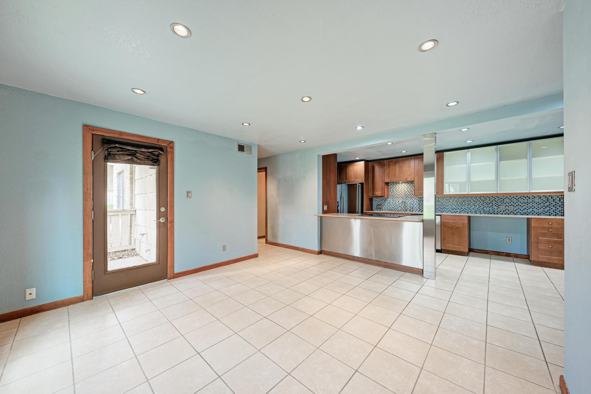 8210 Bent Tree Road, Unit 138 Austin, TX 78759 - Photo 22 of 23 Kitchen featuring tasteful backsplash, wood finish cabinetry, freestanding refrigerator, open floor plan, and recessed lighting
