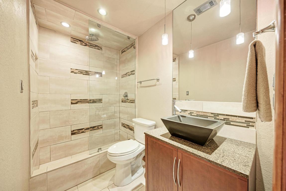8210 Bent Tree Road, Unit 138 Austin, TX 78759 - Photo 18 of 24 a bathroom with a granite countertop sink toilet and shower