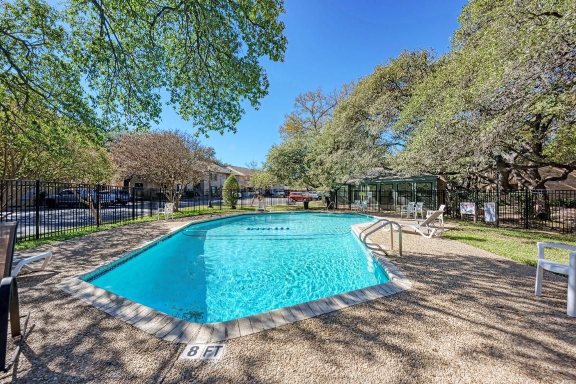 8210 Bent Tree Road, Unit 138 Austin, TX 78759 - Photo 22 of 24 a view of a swimming pool with a bench and trees in the background