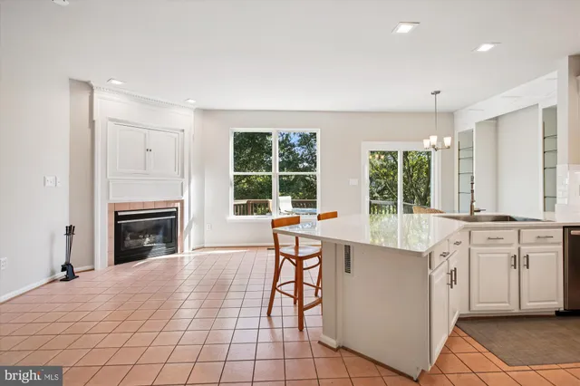 a kitchen with stainless steel appliances granite countertop a refrigerator a stove top oven a sink dishwasher and wooden cabinets with wooden floor