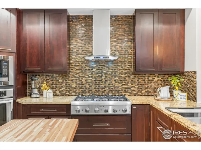 a kitchen with granite countertop stainless steel appliances wooden cabinets and a sink
