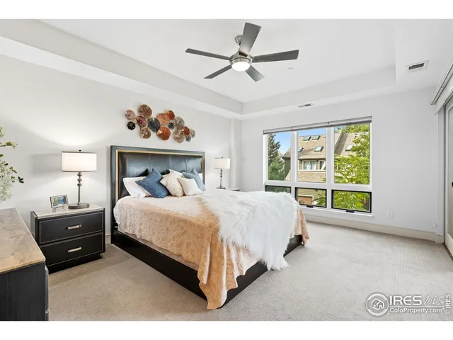 a bedroom with a bed a window and a chandelier