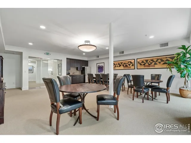 a kitchen with stainless steel appliances granite countertop a refrigerator a sink a stove a dining table and chairs