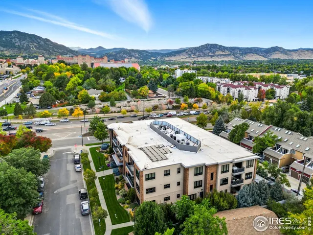 an aerial view of residential houses with outdoor space and parking