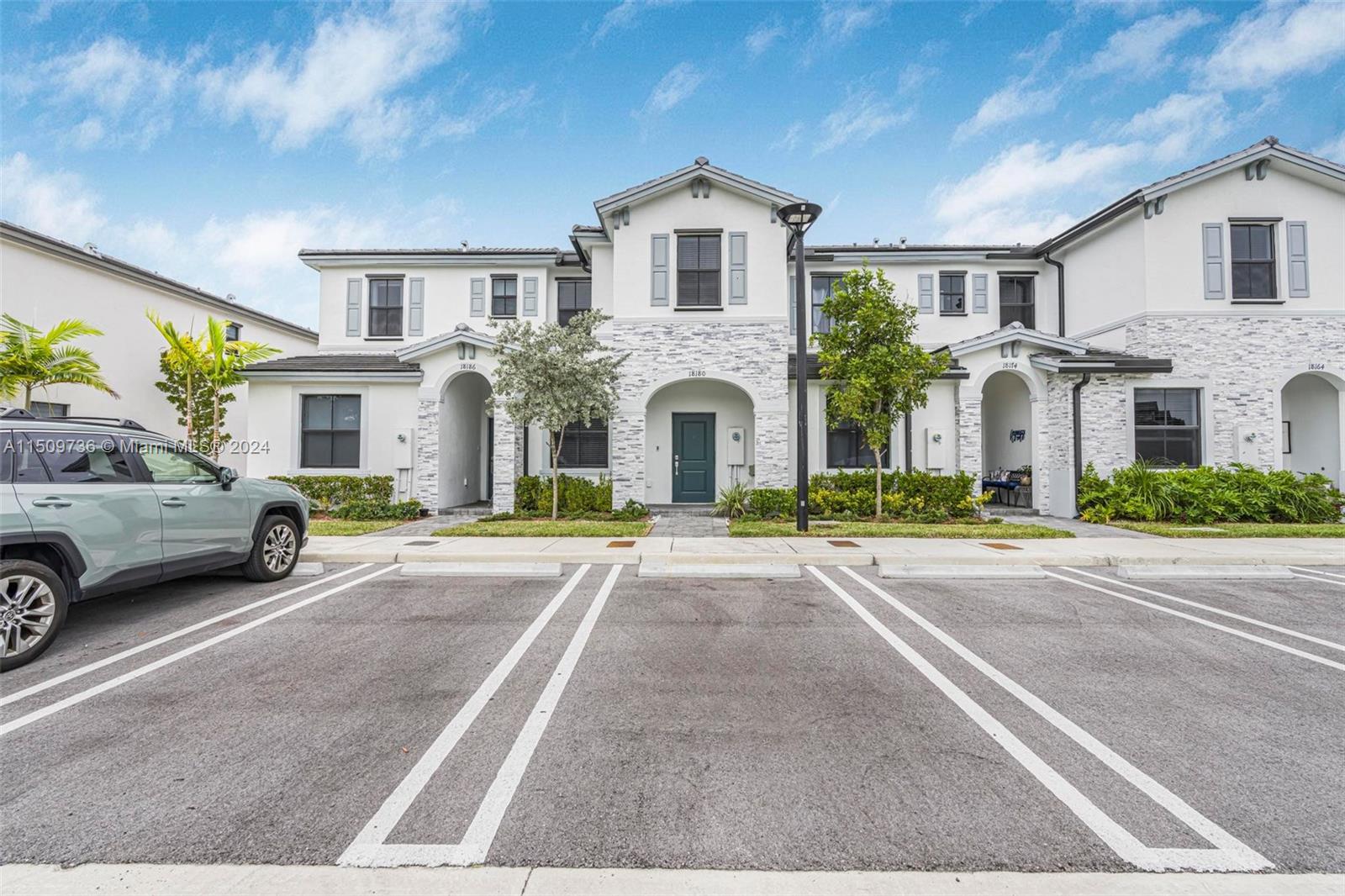 18180 Southwest 148th Road, Unit 18180 Miami, FL 33187 - Photo 1 of 29 a view of a white house with a outdoor space and a car parked in front of it