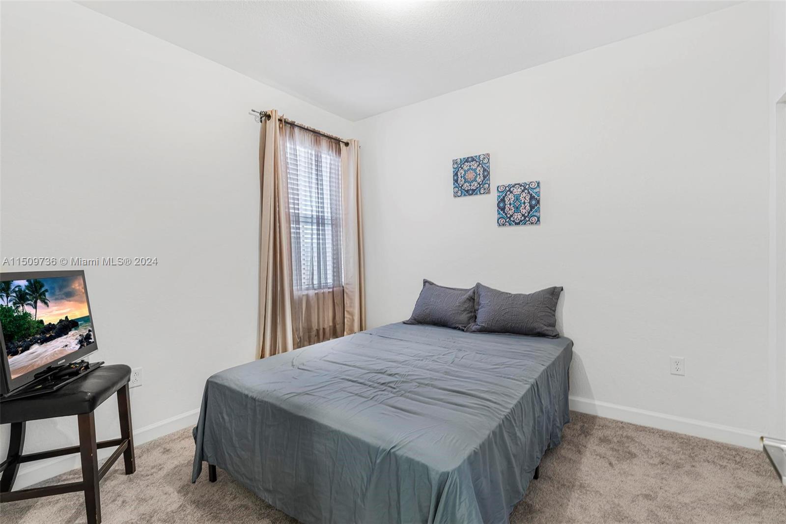 18180 Southwest 148th Road, Unit 18180 Miami, FL 33187 - Photo 13 of 29 a bedroom with a bed and a window