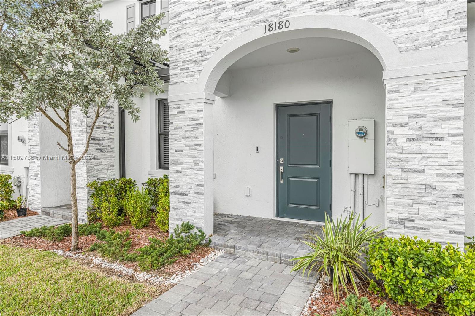 18180 Southwest 148th Road, Unit 18180 Miami, FL 33187 - Photo 29 of 29 a front view of a house with garden