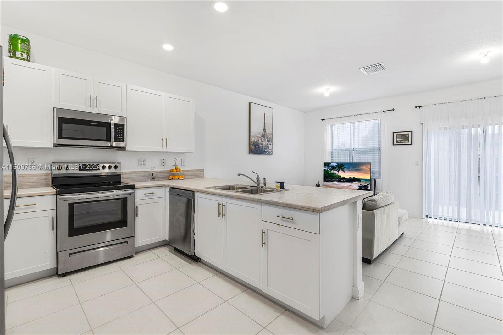 18180 Southwest 148th Road, Unit 18180 Miami, FL 33187 - Photo 3 of 29 a kitchen with stainless steel appliances granite countertop a sink and a stove