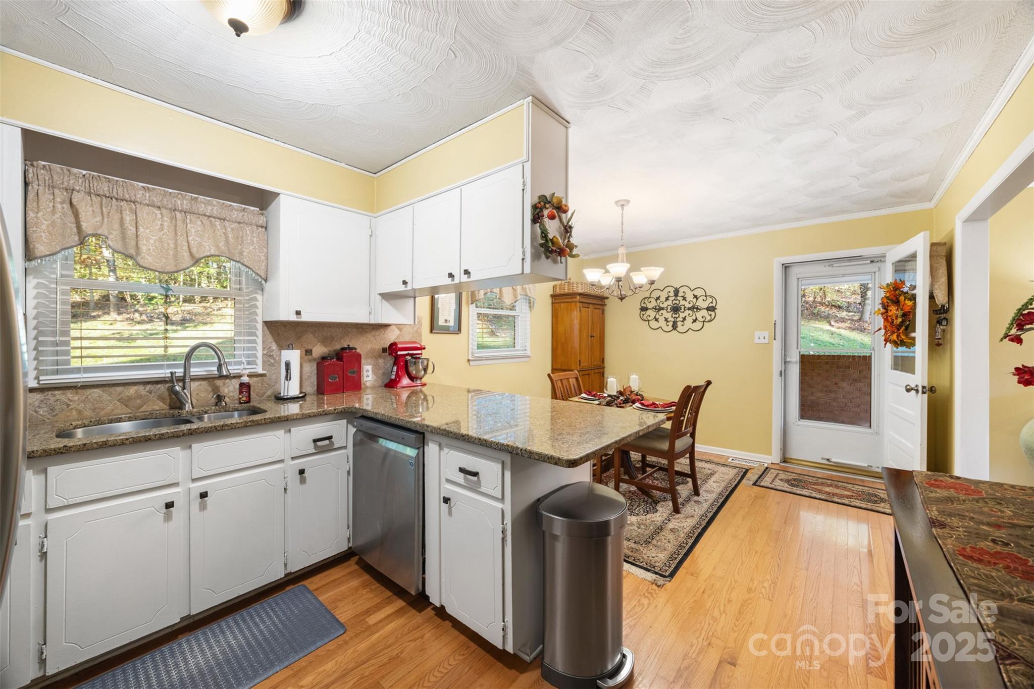1711 McCombs Street Newton, NC 28658 - Photo 12 of 41 a kitchen with stainless steel appliances granite countertop a sink dishwasher and cabinets with wooden floor