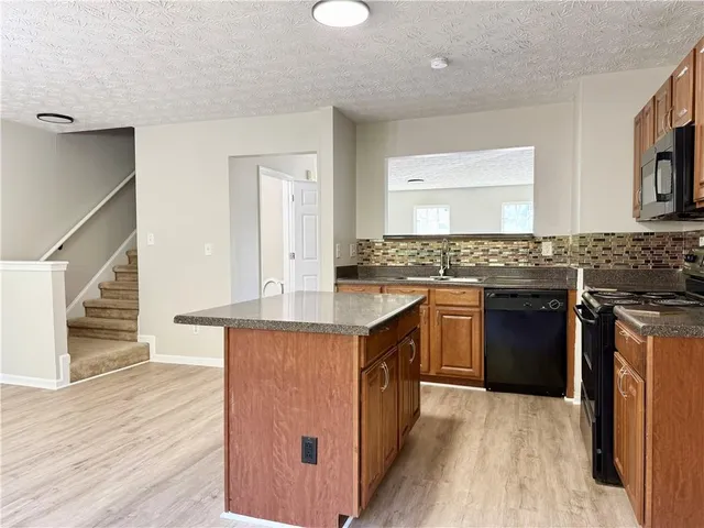 a kitchen with stainless steel appliances granite countertop a stove and a sink