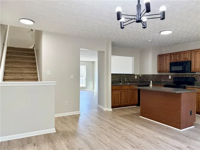 a kitchen with stainless steel appliances granite countertop a stove a sink and a refrigerator