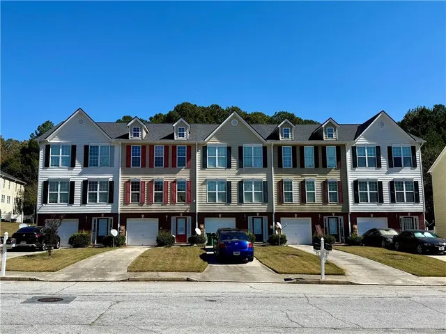 a view of a brick house with many windows and yard