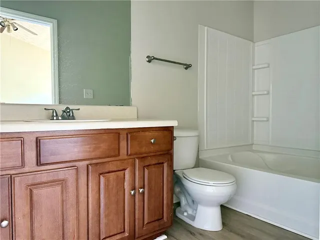 a bathroom with a sink toilet vanity and tub