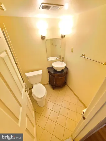 a bathroom with a granite countertop toilet and a sink