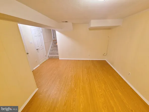 a view of a big room with wooden floor and entryway